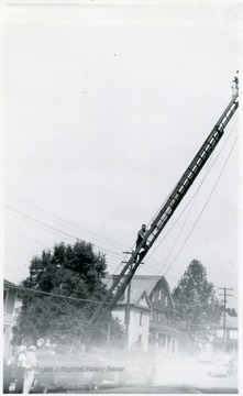 A photograph of two men climbing a ladder as part of fire safety training.