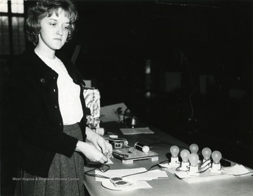 A photograph of Susan Hood, a student at Morgantown High School, at what appears to be the high school's science fair.