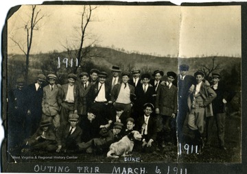 Group of unidentified men with M. Hall's dog, Duke.