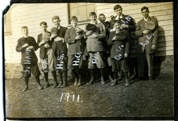 J. Hall is the first boy on the left; every one take its hat and holds it against their chest.
