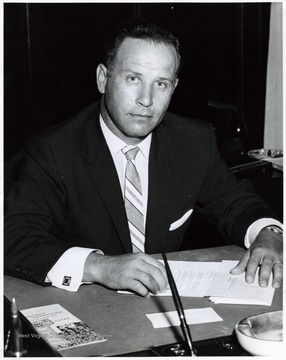 A photograph of Miles Stanley seated at his desk.