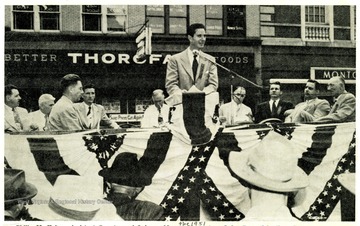 'Philip M. Kaiser, Assistant Secretary of Labor, addresses the 1951 Morgantown Labor Day Celebration.  George A. Crago, third from left, was master of ceremonies for the affair.  Labor and government representatives shown on the speakers stand are, left to right, Richard Kennel, reception committee, commissioner of Labor 1957-.  William Quinn, AFL organizer; Crago, William Radford, AFL labor union; William Hynes, UMW District 4 president, Kaiser, Senator M.M. Neely, State Attorney General William Marland, Eugene A. Carter, state federation of labor AFL president and T. C. Dethloff, AFL organizer.  Senator Harley M. Kilgore was seated directly behind the speaker and is not shown in the picture.
