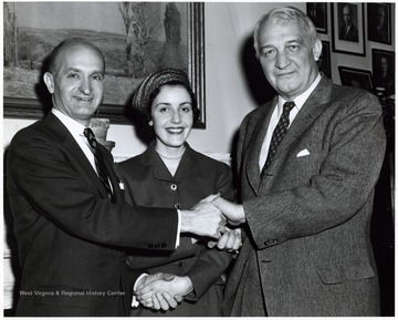 A photograph of Senators Chapman Revercomb and John Hoblitzell, Jr. shaking hands with an unidentified woman.