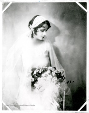 Grace Martin Taylor appears to be in a wedding dress holding a bouquet of flowers.