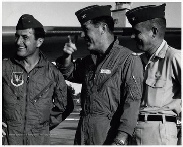 A photograph of Brigadier General 'Pete' Everest (left), Colonel Yeager (center), and Colonel 'Andy'  Anderson (right) standing next to aircraft.