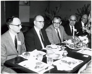 A photograph of an unidentified group seated at a table.