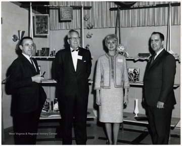 A photograph of Jack Jackson (second from left), Foster G. Mullinax (far right) and two other unidentified individuals in front of an arts and crafts display.