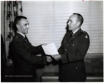 'Col. W. N. Harris, Dir. D/M&amp;TE, presents a letter of Commendation to 2/Lt. David L. Cain, CE Div., for instructor of the month of March 1966.; Publication of this photograph is not authorized unless by a public information office as so noted here - on its use for commercial advertisement must be approved by the Public Information Office of the Chief of Information Department of the Army, The Pentagon Washington 25, D. C. If published please credit as U.S. Army photograph.' 