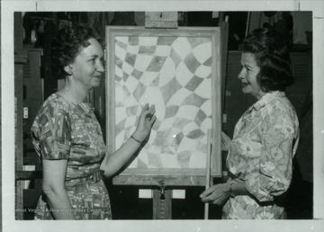 Grace Martin Taylor at a painting talks with a woman. 