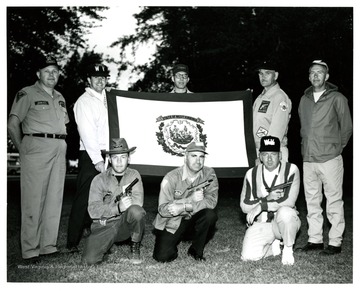 'Competing at the National Pistol Championships at Camp Perry, Ohio this week is the West Virginia State Civilian Pistol Team.  Left to right kneeling are Edward Williams of Summersville; L.K. Waters, Parkersburg; and Hartley J. Perego, Huntington.  Standing, left to right, are John Heis, Morgantown; John Hash, Charleston (Gold Team Captain); Ira S. Latimer, Morgantown; R. T. McCutcheon, Summersville (Blue Team Captain); and Paul Blair, Parkersburg, West Virginia.