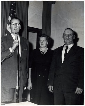 An unidentified couple standing next to Glen Zinn (holding microphone).