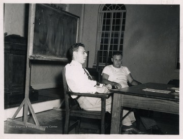 Two men seated at a table.