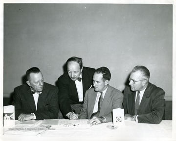 Standing is Samuel Karkow; seated from left to right Clete W. Smith, John D. Spencer and Lawrence Snyder.