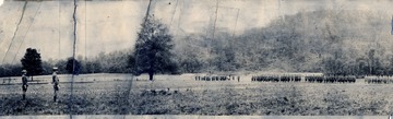 A photograph of the National Guard drilling in a field.