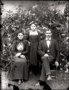 Man, woman, and girl pose for portrait outdoors.