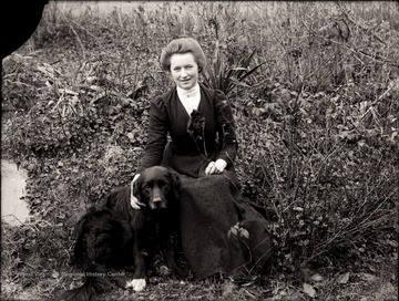 A portrait of woman with her dog by her side.