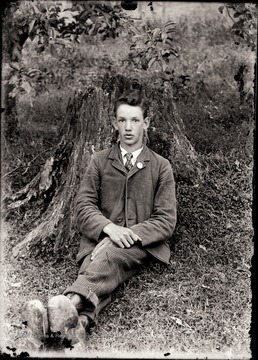 A portrait of young man who sits at the bottom of tree in Helvetia, W. Va.