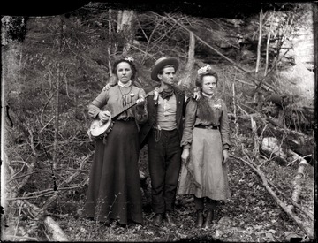 A portrait of a young man and two young women; one of women poses with a banjo. 