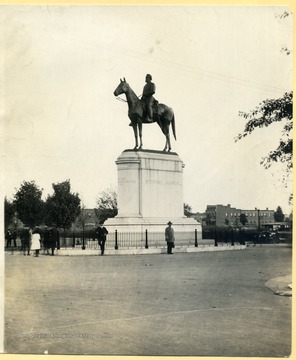 Jackson monument with men leaning on the fence surrounding the statue.