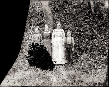 A portrait of three girls and a boy taken outdoors