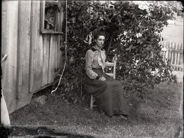 A portrait of seated woman sitting just outside of the house, Helvetia, W. Va.