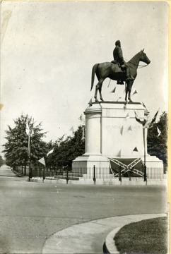 The statue is decorated with strings of flags and a confederate state flag is placed at the foot of pedestal.