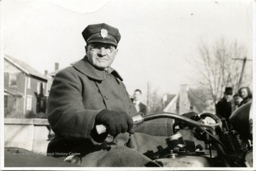 An unidentified man in uniform on a motorcycle.