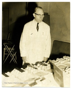 An unidentified man appears to examine eggs on display.