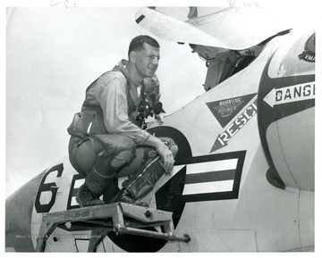 An unidentified pilot poses next to an airplane.