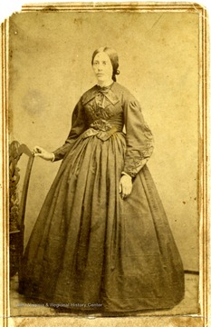 The dress and hair style were the fashion of the day during the 1860's. the young woman is not identified. 