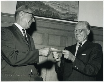 'Lloyd M. Jones(left) presenting check to Director of Athletics Robert N. Brown(right) for refund of sales tax from State Tax Commissioner for tax(sales)inadvertently paid to the State of W. Va. on room and meal for athletes in dormitories paid from the Athletic Fund.'