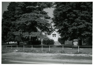 An entrance to the church peeks through the lush green.