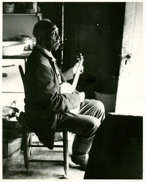 Clarence Tross with a banjo on his laps.