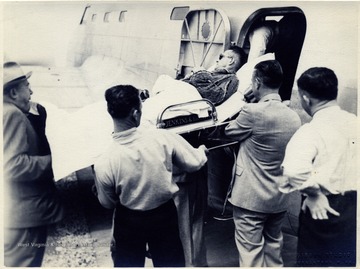 'First Army plane of field-DCZ hospital plane. This picture shows the removing of Major Ennis(WVU) for treatment in Walter Reid Hospital. Left to right: Col. C. C. Robison, Clyde Hoskins, Dr. Earl N.McCue, Chas E. Jenkins in airplane.'