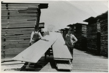 This photograph was published in the book, "Tumult On The Mountain" by Roy B. Clarkson, as Fig. 19. The caption with image includes: "Piling panel poplar in then yard for air drying. The various layers of the pile are separated by 1 X 4 inch stickers placed across the pile.Courtesy WVU LIbraries, A&amp;M 1630, Brown, D. D. Collection"