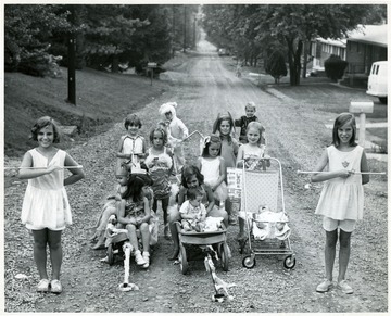'Child Power reigned over Hoffman Street last night when 12 area youths staged a parade down to the Wiles Hill street. Said Mrs. Karl Engle, mother of two of the youngsters: "The children did this all by themselves, the parents did not help them at all." David Fawley, 18 months old and his sister Marsha 6, reigned as King David I and Queen Marcia. Shown are Sandy Hess, Ruth Engle, Patty Fawley, Jennifer Davis, Marcia and David Fawley, Shawn and Cindy Overley, Kenneth Ray Lindamood, Joanne Lemmon, Rachel Engle, Kersten Davis, Stephanie Davis, Grant Overley and Carl Sullivan. Invitations to area residents were distributed. (Photo by Shelby Young.'