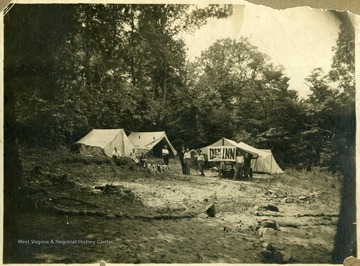 'Campers at their camp site "Dew Drop Inn", on the Cheat River opposite of Mont Chateau. From left to right: Charles W. Louchery-"Judge", James W. Burns-Dishes, N. Ott. Garrison- "Hog" Cook, Mal. Turner-"Wasn't Jim", Roy J. Jamison-"Ace", Charles Hodges- "Tar", French Yoke-"Lanky"- Roscoe P. Posten- "biggest eater" and Sid Treat- "Stawberrian"