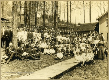 'This picture was taken at Aunt Kate Raines House, picnic, church yard, Evenwood, 140 attended.'  See original for names of the people.