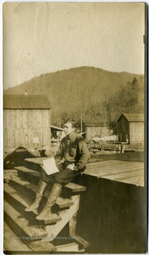 Walter Dayton sits on a platform in the logging town located in Randolph County.