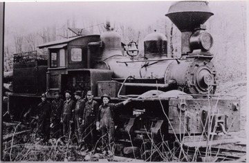 Men posed for a portrait in front of a train.