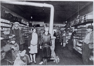 Portrait of a posed group in the store that is currently Minnichs Florist. One daughter is Opal Williams, longtime teacher of Webster County.
