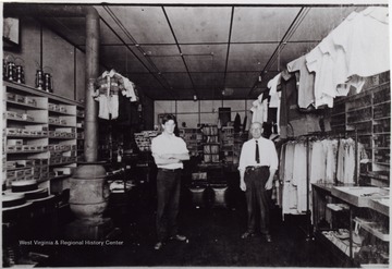 Two men posed in a store "where lodge at Camden now sits before block burned, men are Ross's."