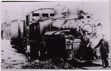 Four men are posed next to a train.