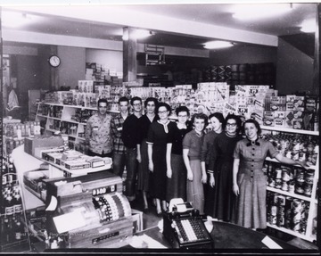 Portrait of workers in front of shelves of groceries.