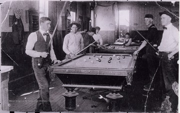 Portrait of men playing a game of pool. 