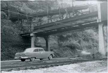 Cars pass underneath the coal conveyor in this portrait taken from the railroad tracks.
