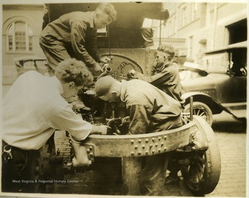 In this portrait, students are repairing a Garfield truck.