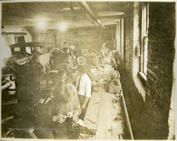 This portrait is a general view of one part of the laboratory showing soldiers at work on the machine at the benches. 