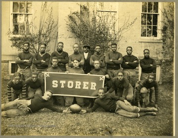 Storer College Football team in uniform near building.