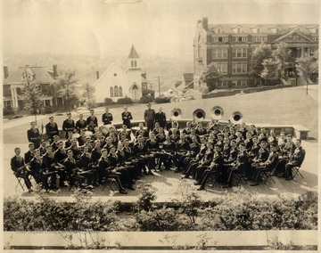 WVU Marching Band sitting in front of Wise Library. The Lutheran Church and Colson Hall are visible in the background.